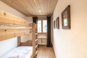 a room with two bunk beds and a window at Appartement au centre de megève in Megève
