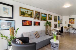 a living room with a couch and paintings on the wall at Ferienwohnung Kupfer in Niestetal