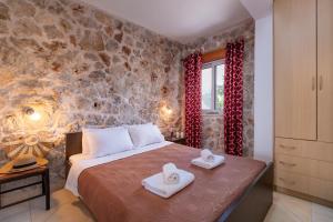 a bedroom with a bed and a stone wall at Apartment with Sea view B in Tsoukalades +19 photos
