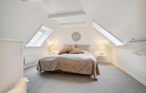a bedroom with a bed in a room with skylights at Pet Friendly Home In Rønne With Kitchen in Rønne +18 photos