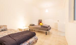a bedroom with two beds and a table in it at Casa Io in Mindelo