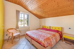 a bedroom with a bed and a chair and a window at La Casa di Lady in Ceriale