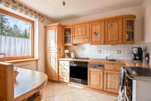 a kitchen with wooden cabinets and a stove top oven at Mendelhaus in Mendola +13 photos