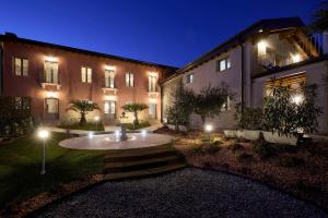 a courtyard with a fountain in front of a building at night at Abaye I Champagne Charm Adults Only in Soiano del Lago