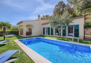 eine Villa mit Swimmingpool vor einem Haus in der Unterkunft Flor Begur in Begur
