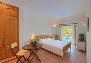 ein Schlafzimmer mit Bett, Tisch und Balkon in der Unterkunft Flor Begur in Begur + 10 Fotos