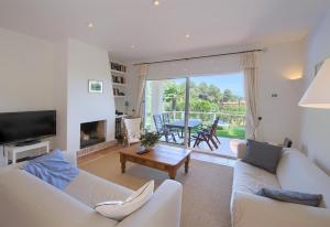 ein Wohnzimmer mit zwei weißen Sofas und einem Fernseher in der Unterkunft Flor Begur in Begur