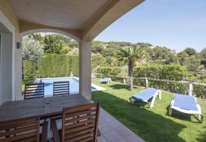 eine Veranda mit Tisch und Stühlen und ein Pool in der Unterkunft Flor Begur in Begur