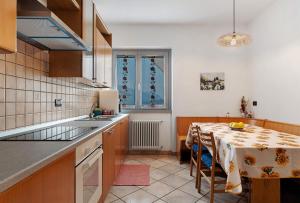 a kitchen with a table and a dining room at Ciclamino Superior Otto in San Lorenzo in Banale