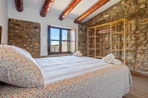 a bedroom with a large bed and a stone wall at La Casa Gran Clariana in Gornal +20 photos