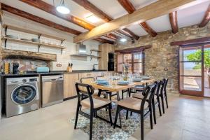a kitchen with a wooden table and chairs at La Casa Gran Clariana in Gornal