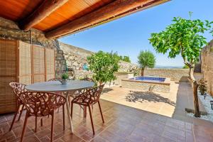 a patio with a table and chairs and a pool at La Casa Gran Clariana in Gornal