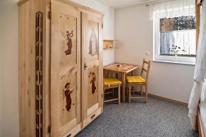 a room with a wooden cabinet with a table and a window at Haus Ruther - Wohnung 1 in Bad Saulgau