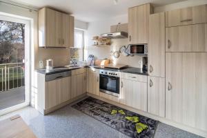 a kitchen with wooden cabinets and a floor with a rug at Haus Ruther - Wohnung 1 in Bad Saulgau +18 photos