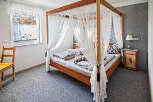 a bedroom with a canopy bed with mosquito nets at Haus Ruther - Wohnung 1 in Bad Saulgau