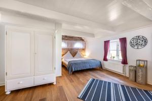 a bedroom with a bed and a blue rug at Knutzenswarft - Strandläufer in Westerhever