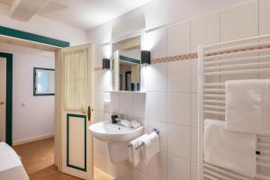 a white bathroom with a sink and a mirror at Knutzenswarft - Strandläufer in Westerhever +26 photos