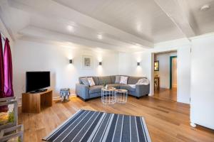 a living room with a couch and a tv at Knutzenswarft - Strandläufer in Westerhever