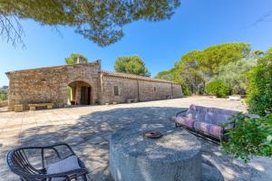 a stone building with a couch and a chair at Tenuta Pizzola in Nociglia