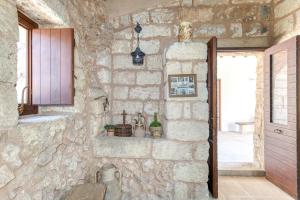 a stone kitchen with a stone wall with a shelf at Tenuta Pizzola in Nociglia