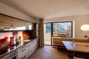 a kitchen with a sink and a large window at Sonnleiten Sonne Mond u Sterne in Collepietra