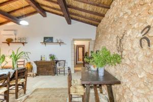 a dining room with a stone wall and a table and chairs at Tenuta Pizzola in Nociglia +26 photos