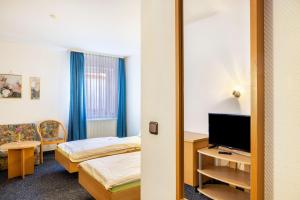 a hotel room with two beds and a television at Gasthaus, Hotel am Dreienberg in Friedewald