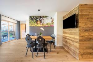 a dining room with a table and chairs and a tv at Leierhof Olivia in Rodengo