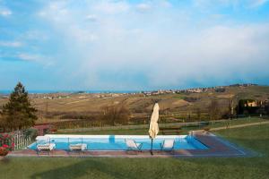 a swimming pool with chairs and an umbrella at Casa Vacanze Elios in Valdamonte