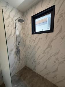 a shower in a bathroom with a window at villa du bonheur in Koh Samui