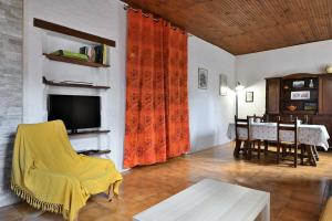 a living room with a television and a dining room at Gite Decauville in Uchentein
