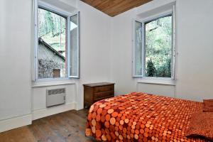 a bedroom with a bed and two windows at Gite Decauville in Uchentein
