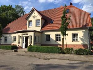 ein weißes Haus mit rotem Dach in der Unterkunft McIntosh in Groß Wokern