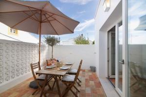 a wooden table with an umbrella on a patio at Casa de Benafim 1 in Benafim