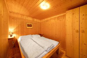 a bedroom with a bed in a wooden room at Bungalow 34 - Kimbucht in Reichendorf