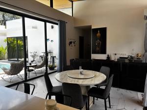 a dining room with a table and chairs at villa du bonheur in Koh Samui