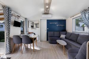 a living room with a couch and a table at Mobile Home du Bois Dormant in Saint-Jean-de-Monts