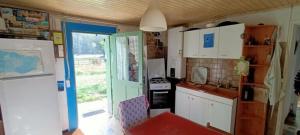 a kitchen with white cabinets and a blue door at Petite maison rustique et atypique in Hourtin