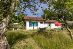 a house in the middle of a field at Petite maison rustique et atypique in Hourtin +13 photos