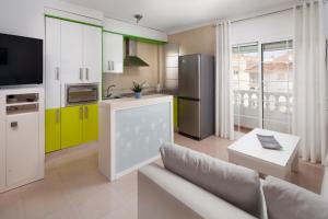 a living room with a couch and a kitchen with yellow cabinets at Ático el morche in El Morche