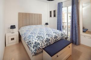 a bedroom with a bed with a blue and white comforter at Ático el morche in El Morche