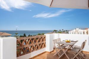 a balcony with a table and chairs and the ocean at Ático el morche in El Morche