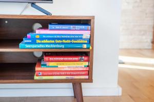 a stack of books sitting on a shelf at Casa Meeresbrise Marlow in Marlow