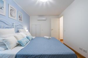 a blue and white bedroom with a bed at Villa Daisy in Quartu SantʼElena +35 photos