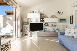 a living room with a blue couch and a flat screen tv at Villa Daisy in Quartu SantʼElena