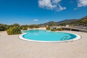 a swimming pool in a resort with mountains in the background at Villa Daisy in Quartu SantʼElena