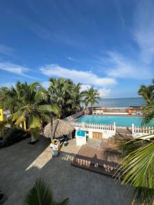 a view of a pool with palm trees and the ocean at Tolu - Caribbean apartment in Santiago