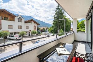 a balcony with a table and a view of a street at Apartment il cuore rosso in Naturno