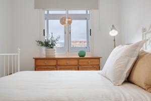 a bedroom with a bed with a window and a dresser at Medano House in El Médano