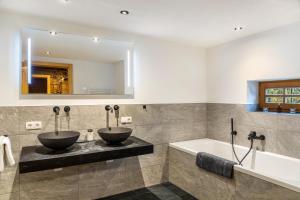 two sinks in a bathroom with a tub and a mirror at Apartment Kracherlemoos in Seefeld in Tirol +32 photos